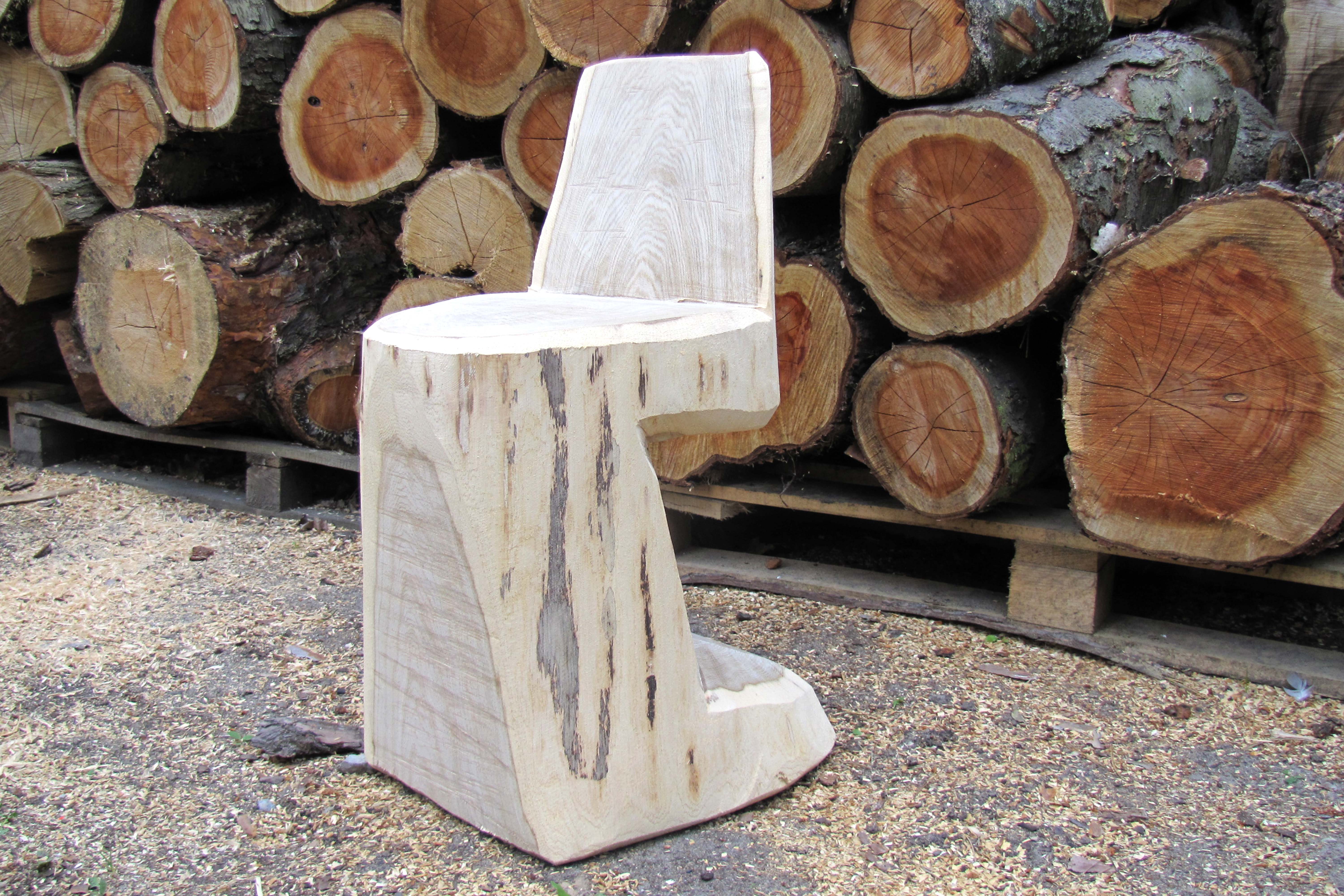 Exemplo de como fazer cadeiras de toro à frente de uma pilha de troncos de árvore