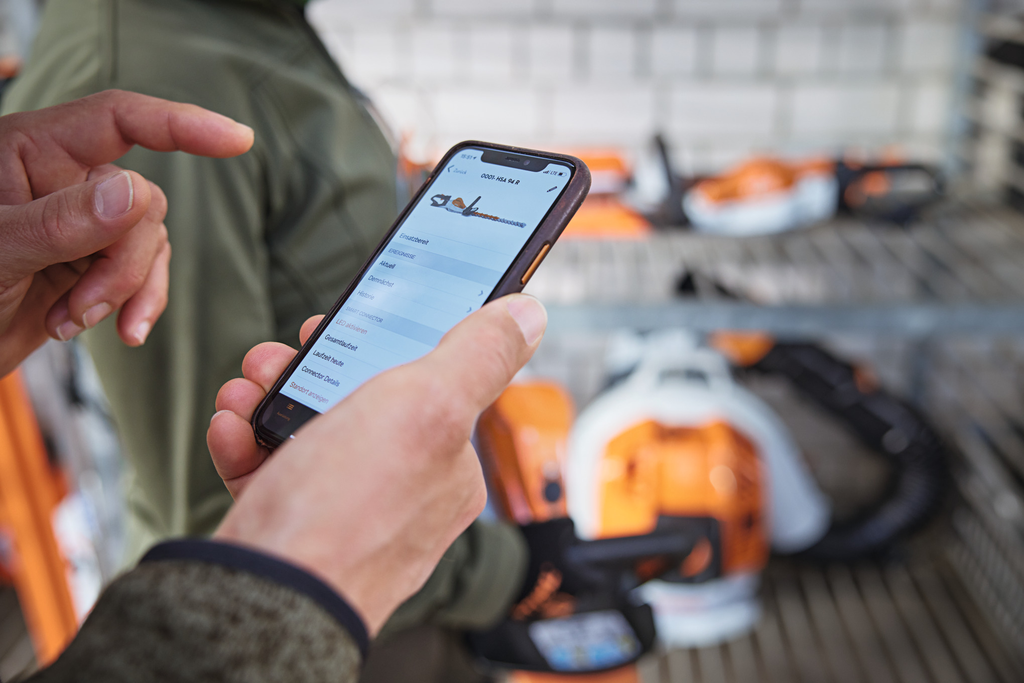 Uma pessoa com um smartphone a ver motosserras na aplicação STIHL connected