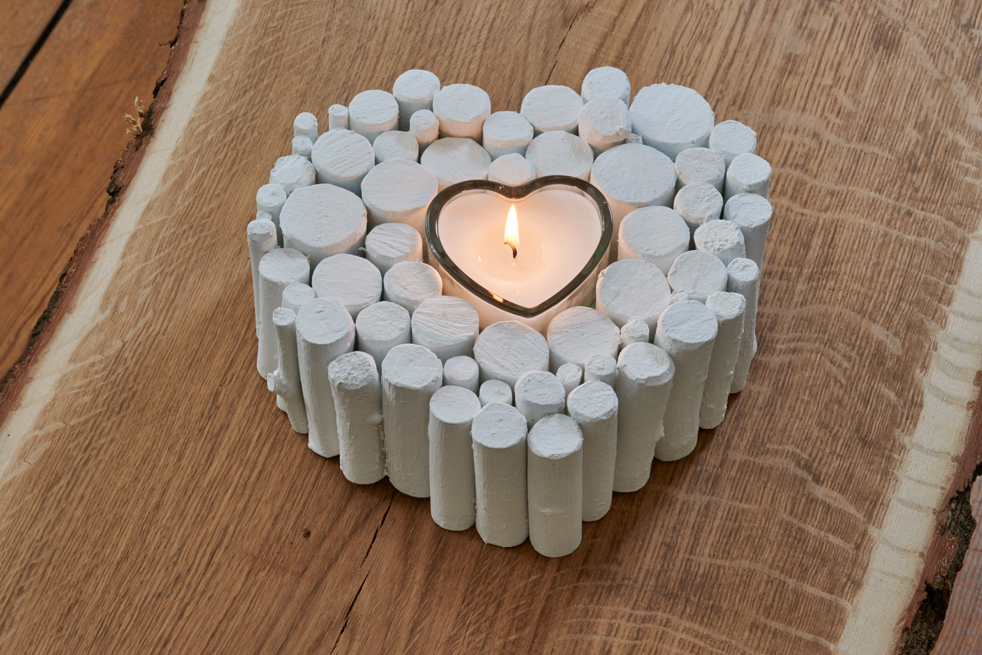 Ornamento de bricolage em forma de coração de madeira feito a partir de um ramo, com uma vela