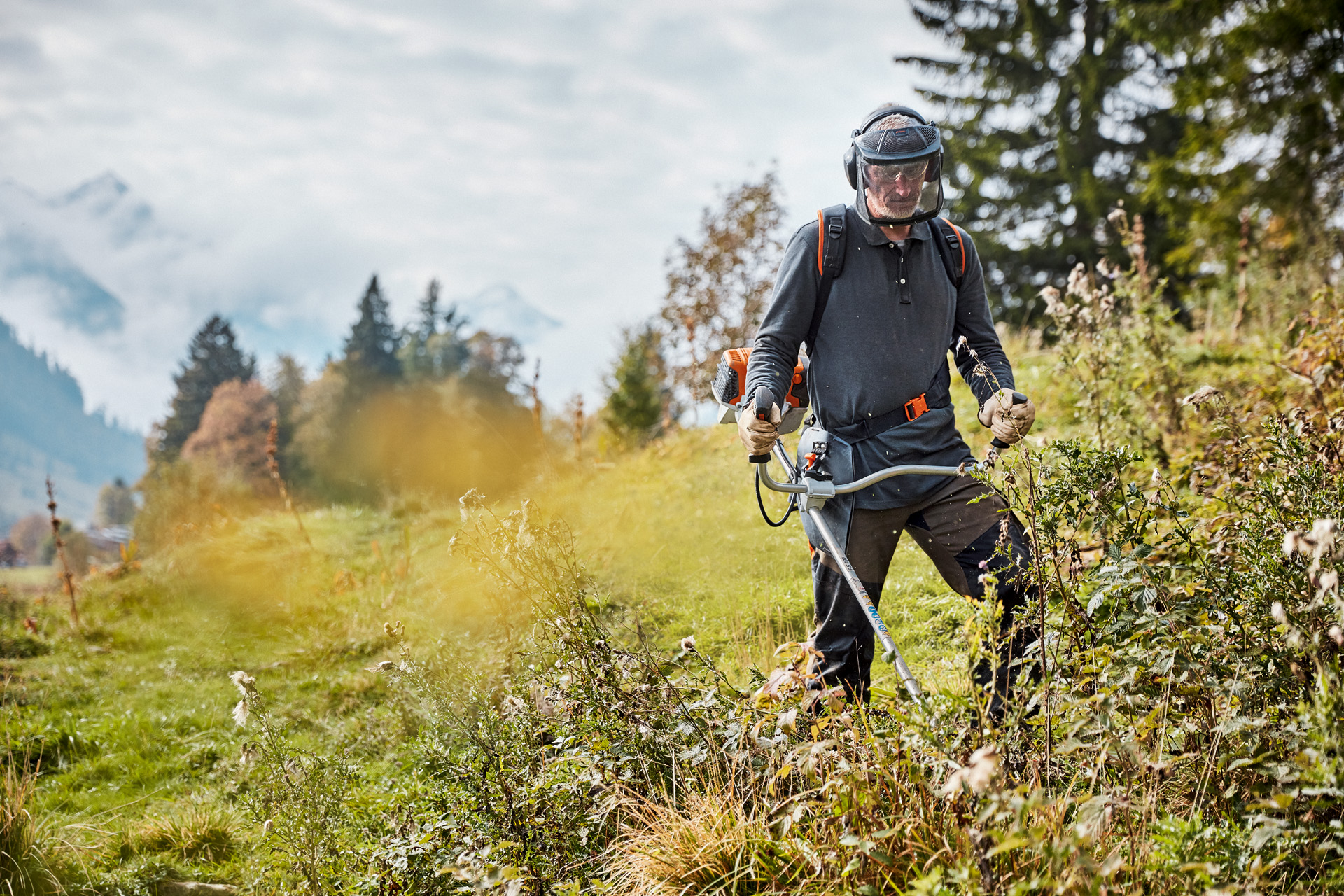 Um homem trabalha com uma STIHL FS 131 num grande prado.