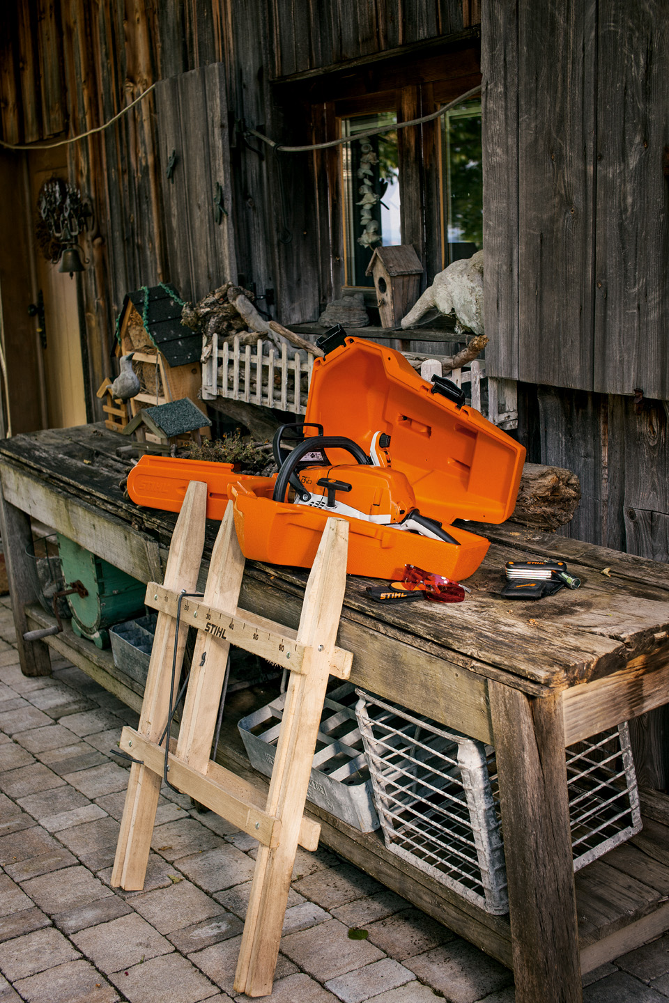 Armazenamento da motosserra STIHL dentro de uma caixa de arrumação de plástico sobre uma mesa de madeira