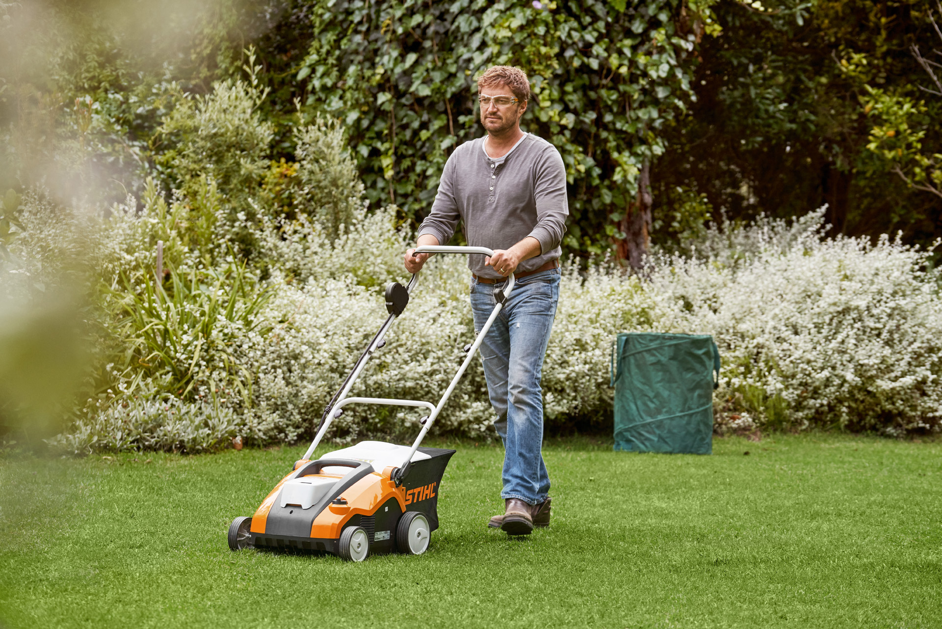 Um homem escarifica um relvado verde com um STIHL RLA 240 – guia de como escarificar um relvado