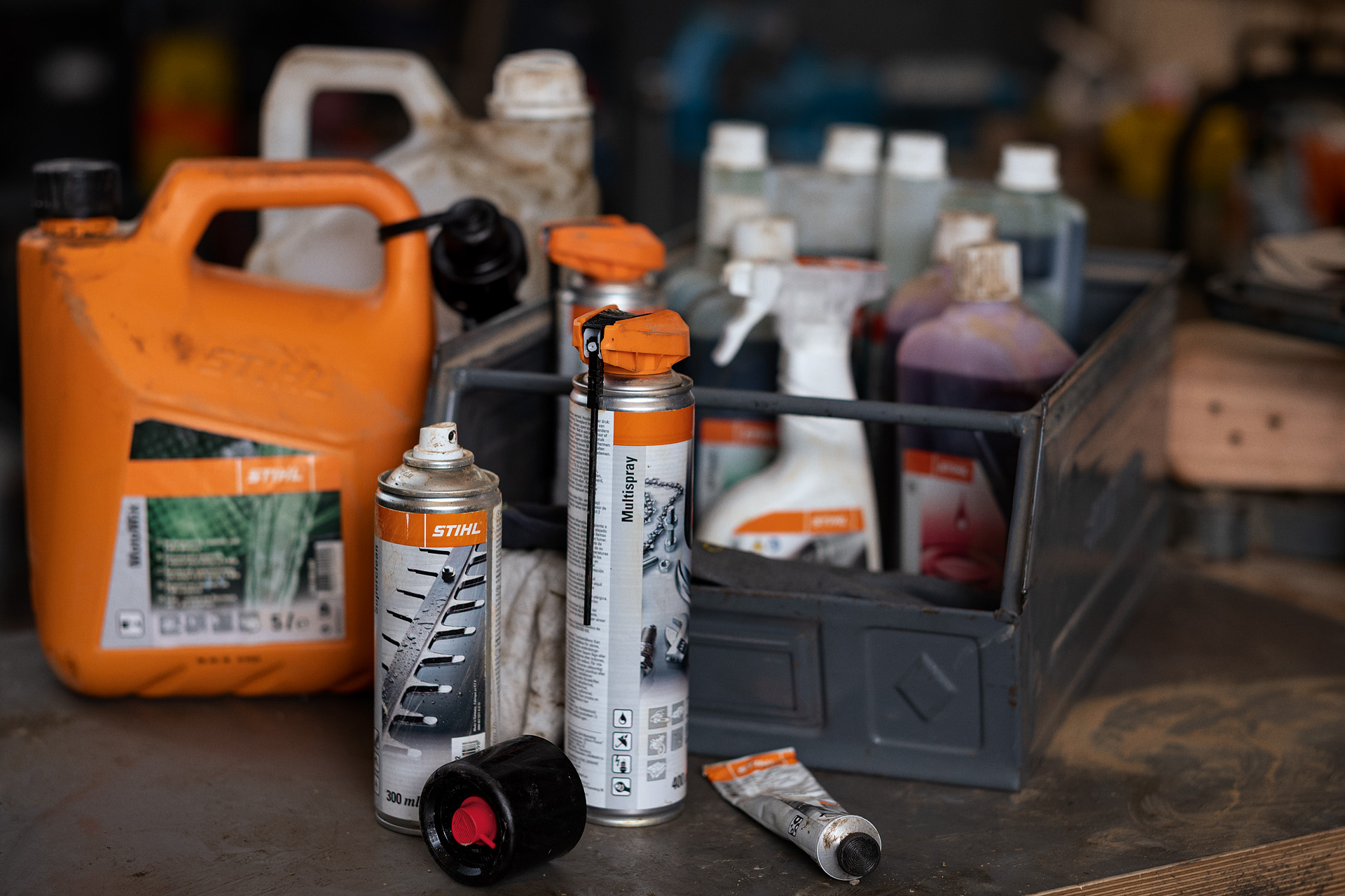 Diferentes combustíveis e lubrificantes da STIHL, alguns deles numa caixa 