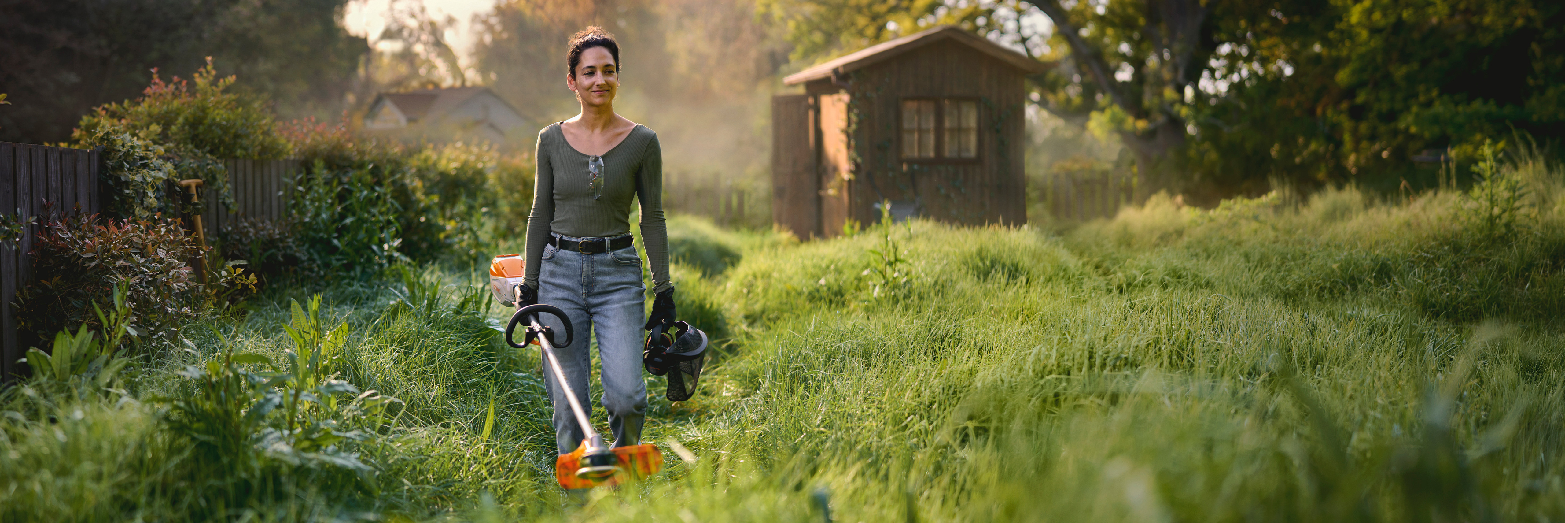 Pai e filho com motosserra STIHL a cortar um tronco de árvore no quintal 