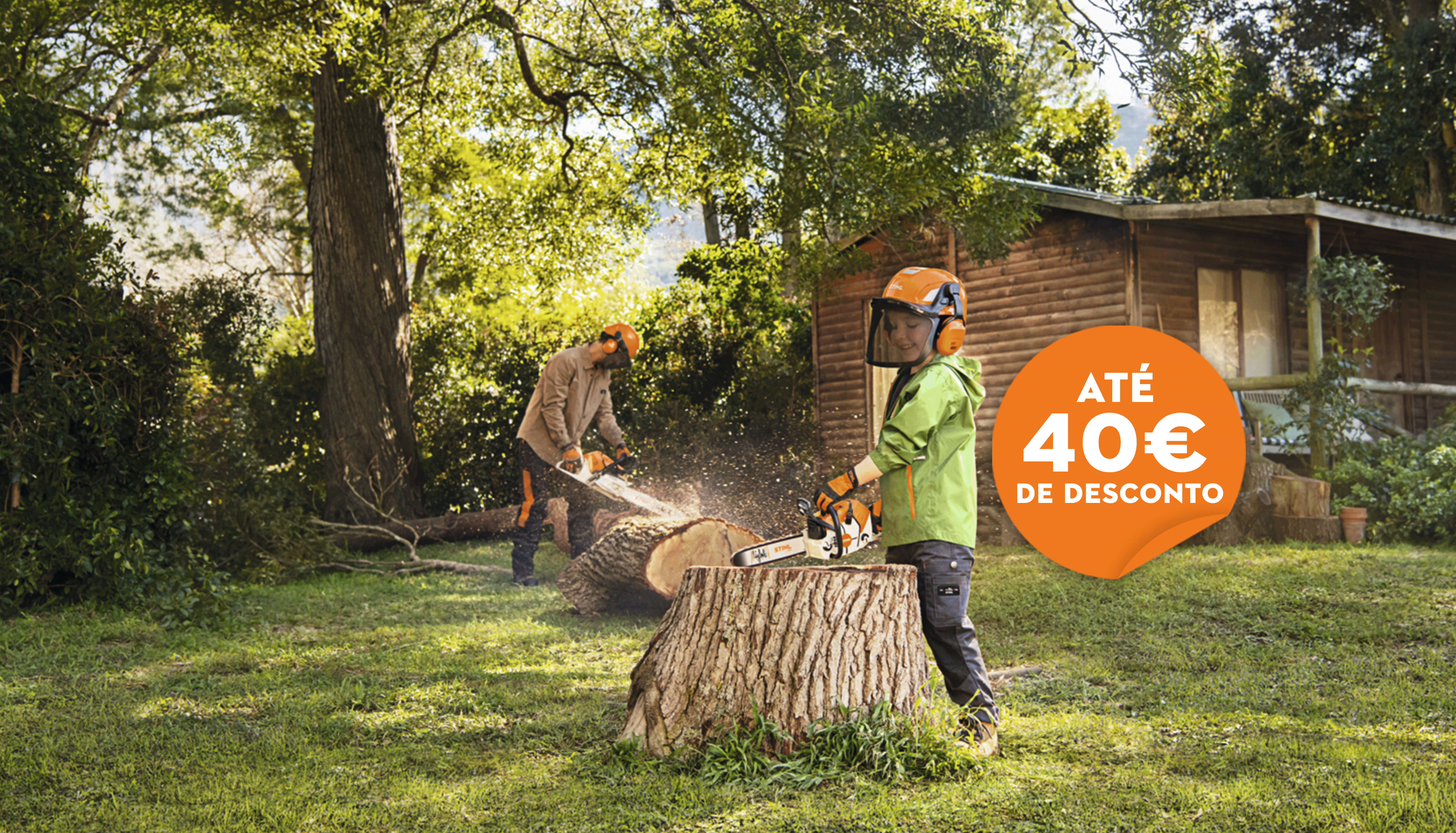 Pai e filho com motosserra STIHL a cortar um tronco de árvore no quintal 