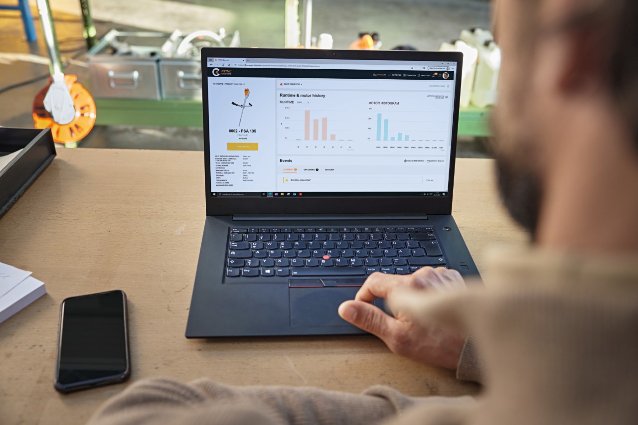 A pessoa senta-se em frente ao seu computador e verifica o estado do aparelho com o portal ligado STIHL