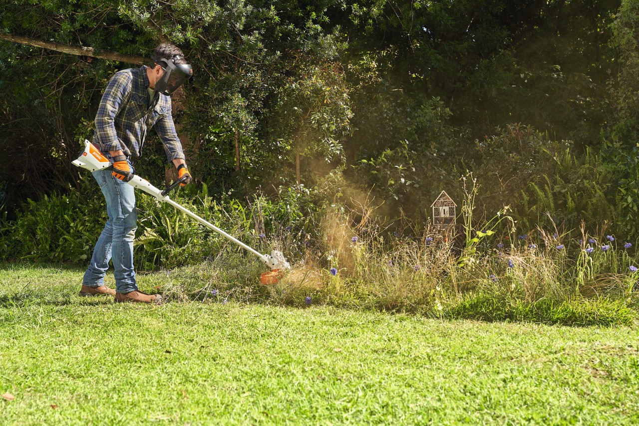 Um homem a cortar um prado de flores silvestres com a STIHL FSA 57