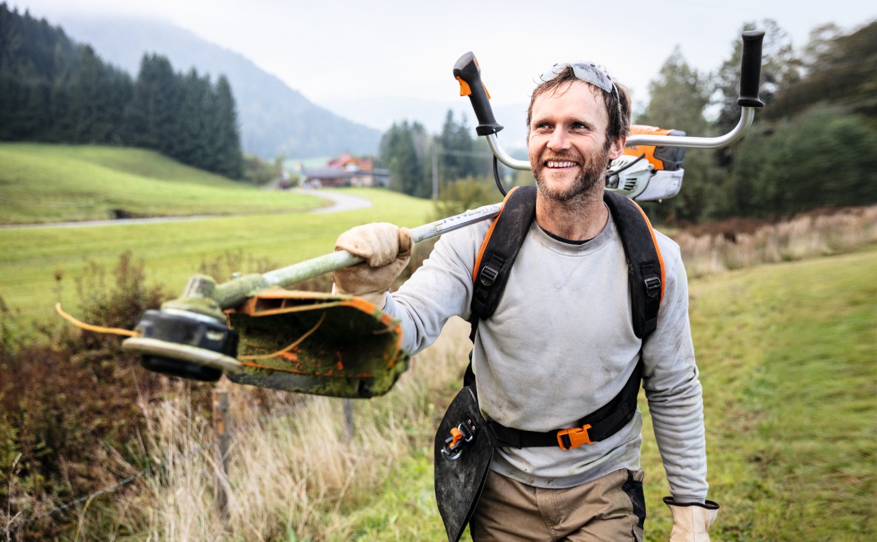 Homem sorridente a trabalhar com uma motorroçadora FS 91 da STIHL num campo